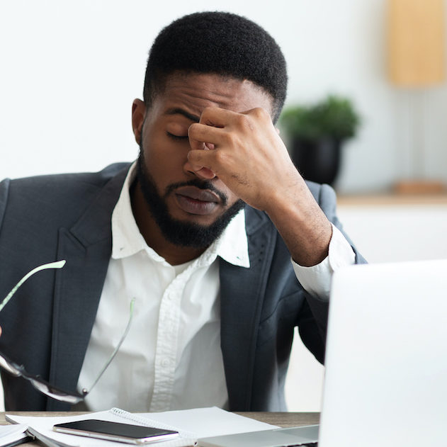 Overworked businessman sitting at workplace after hard day in office managing stress in the workplace