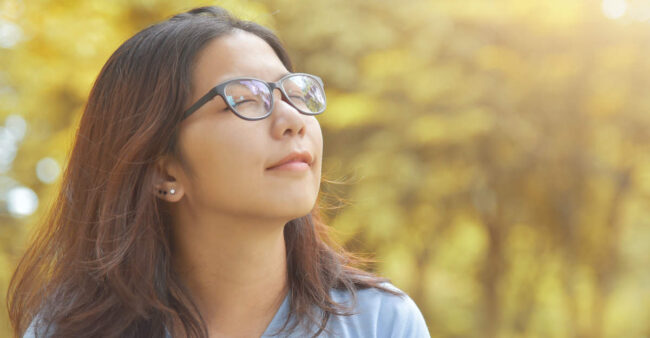 Asian woman breathing deep fresh air. help with anxiety
