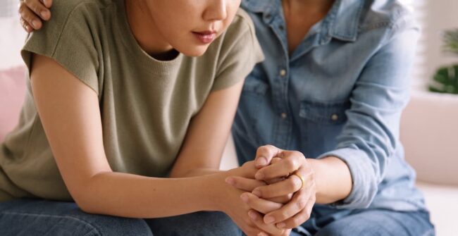 Middle aged asia people old mom holding hands trust comfort help young woman talk crying stress relief at home. Mum as friend love care hold hand adult child feel pain sad worry of life crisis issues. eating disorders and family support