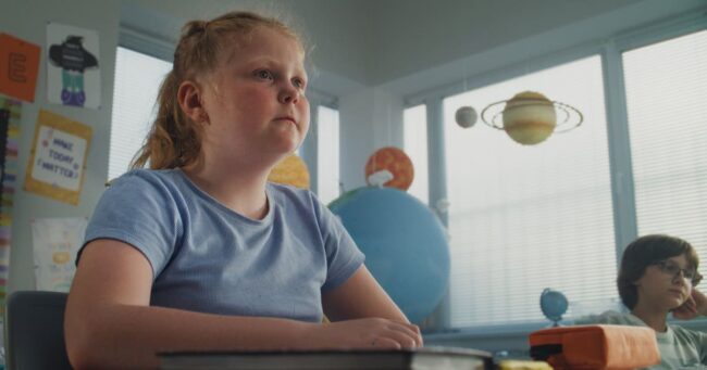 Stressed Primary School Girl Sitting at Desk While Classmates Abusing Her, Throwing Papers back to school anxiety